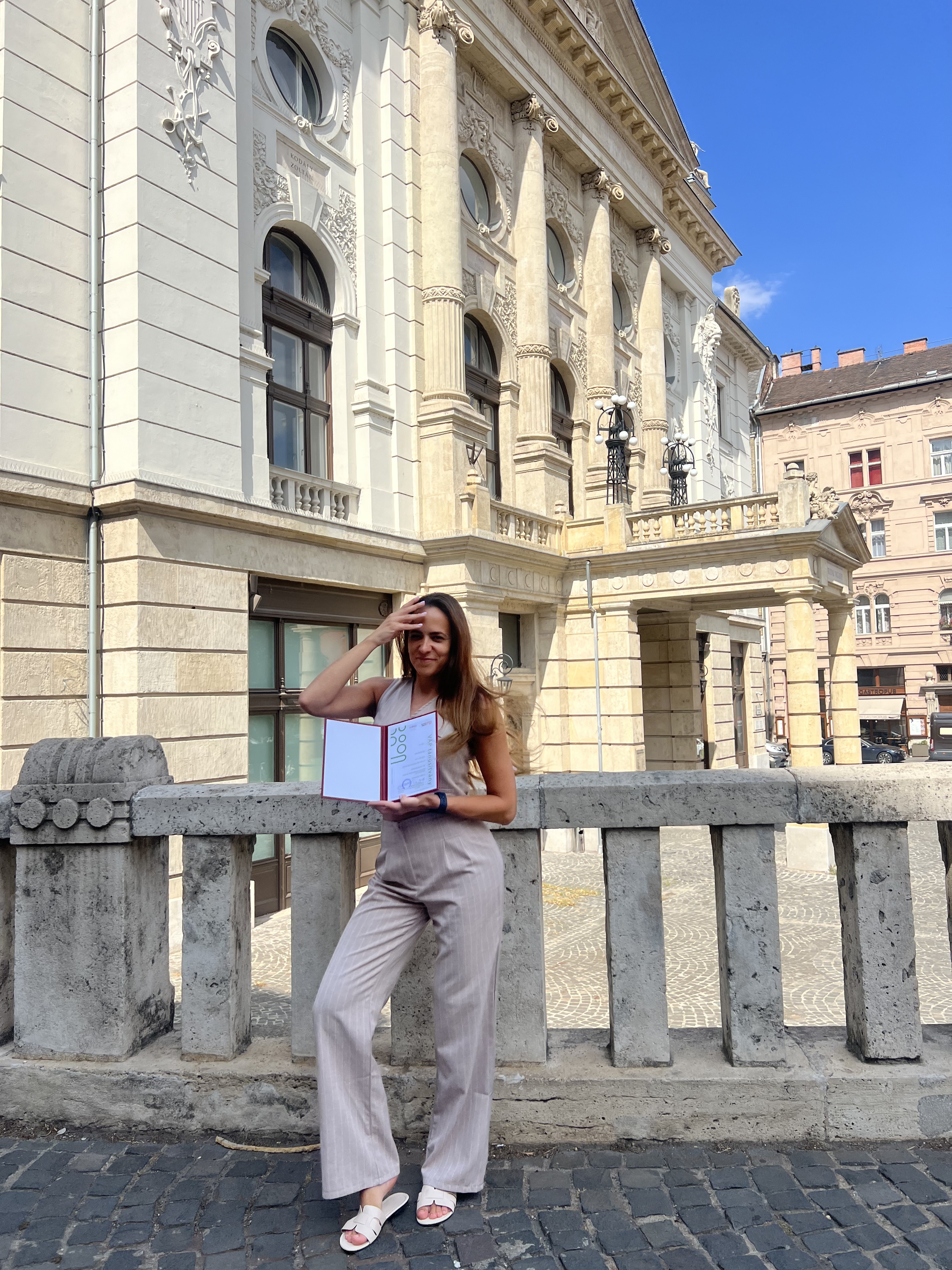 Sipos Viki a Bankárképző képesítésével egy történelmi épület előtt